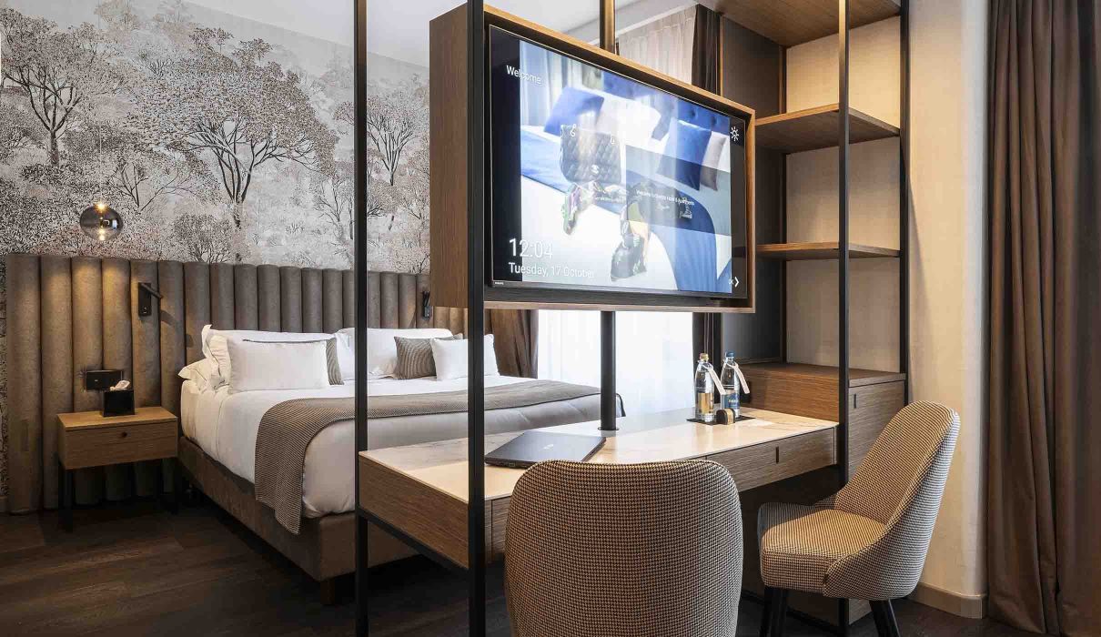 Custom furniture for hotel room: metal structure that houses television, minibar, desk