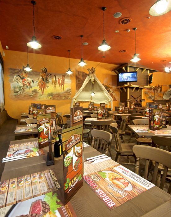 Old Wild West Custom-made furniture for a Western-style restaurant, including wooden tables and chairs, metal fences and bars.