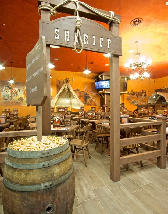 Old Wild West Custom-made furniture for a Western-style restaurant, including wooden tables and chairs, metal fences and bars.