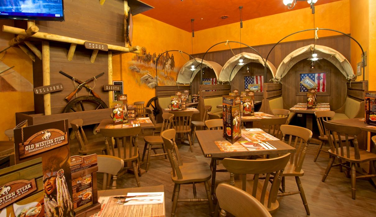 Old Wild West Custom-made furniture for a Western-style restaurant, including wooden tables and chairs, metal fences and bars.