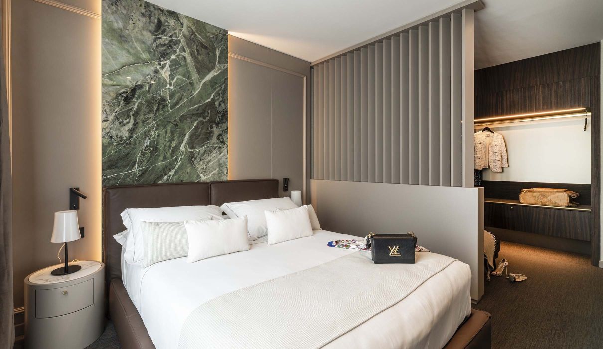 Custom hotel furniture: marble headboard, partition wall for equipped walk-in closet