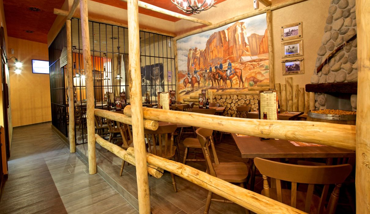 Old Wild West Custom-made furniture for a Western-style restaurant, including wooden tables and chairs, metal fences and bars.